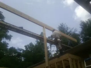 Carpenter setting a ridge beam over a new addition frame — Ice Dam Removal by Roofing Brothers in Big Clifty