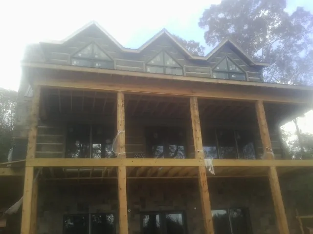 Dormers and porch framing on a large log home under construction — Roof Coating work by our crew in Big Clifty